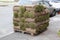 Pallet with stack of turf grass rolls lawn fresh grass to decorate landscape design in residential area