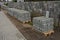 Pallets with curbs ready for road and sidewalk reconstruction. Builders use cheap gray concrete products from a cement plant. sepa