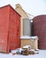 Pallets stacked behind colorful grain elevators in a winter storm