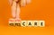 Palliative or hospice care symbol. Concept word Palliative care Hospice care on wooden cubes. Doctor hand. Beautiful orange