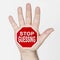 On the palm of the hand there is a stop sign with the inscription - STOP GUESSING