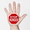 On the palm of the hand there is a stop sign with the inscription - STOP HUNGER