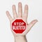 On the palm of the hand there is a stop sign with the inscription - STOP MALNUTRITION