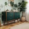 Palm leaf on a modern, teal sideboard with drawers in a luxurious, green living room interior with golden decorations and an uphol
