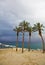 Palm trees and beach canopies in a thunder-storm