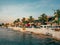 Palm trees and buildings along the water at sunset, in Cozumel, Mexico