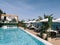 Palm trees in flowerpots near double sun loungers by the pool