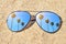 Palm trees in stylish mirrored sunglasses on sand against turquoise sky. Summer vacation on the beach