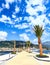 Palms decorating the pier of the modern promenade of Porto Montenegro, flooded with bright sun.