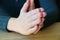 Palms folded in prayer. Girl sits and holds hands in front of her hands clasped together