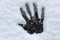 Palms of human hand imprints into white snow covered dark glass surface. Concept of winter fun and cold weather activity