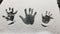 Palms of human hands imprints into white snow covered dark glass surface. Kid`s and adult`s handprints closeup. Concept of winter
