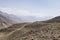 Pamir Highway in the desert landscape of the Pamir Mountains in Tajikistan. Afghanistan is on the left