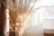 Pampas grass near windowsill with white curtains with bokeh and sunlight. minimalistic pampa concept.Trendy Home Decor.