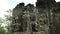 Pan of carved stone face towers at bayon temple