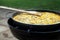 Pan of chicken paella cooking on an outdoor gas cooker