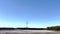 Pan of a cotton plantation and power towers clear blue sky