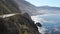 Pan of a cyclist riding along the california coast in big sur