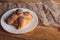 Pan de muerto on a white plate isolated on a wooden table.