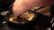 Pan down from arm to man`s hand shaking and stirring a frying pan with meat