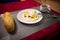 Pan of fried egg, crispy baguette fruit jam and cup of coffee on white rustic wooden table, top view. Breakfast time