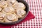 Pan of Frosted Cinnamon Rolls on a Red and White Plaid Tablecloth