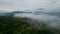 Pan from Japanese hilltop castle to city on early foggy morning