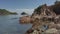 Pan left of beautiful tropical sedimentary rock pattern on a small island islet with patches of sea water. Ends with holiday resor