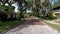 Pan by red brick road and mossy trees clear sunny day in Florida