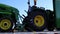 Pan of a semi truck hauling John Deere tractors  clear blue sky background