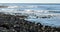 Pan shot across the Pacific Ocean on a rocky shoreline