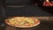 Pan shot of ready vegaterians pizza lying out of the brick oven