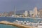 Pan view of Benidorm Poniente beach with port, skyscrapers, boats and mountains in Benidorm, Alicante, Spain with rain clouds on b