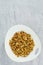 Pancake cereal. Trendy food, mini cereal pancakes in bowl on the table, cement vertical background. Trendy baked mini