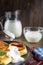 Pancake cheese with a jug and a glass of milk for breakfast on a gray plate, in a rustic style, close-up, sour cream