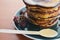 Pancake with dripping honey on a blue plate with raspberries