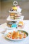 Pancake. Pancakes served with various fruits and blurred image of 3 tier cake stand full with cakes, colorful macarons and muffins