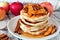 Pancake stack with apples, pecans and cinnamon and maple syrup