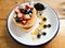 Pancake with strawbery blueberry and honey on wooden table