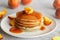 Pancakes with apricot jam and peaches. Pancakes on a plate