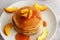 Pancakes with apricot jam and peaches. Pancakes on a plate