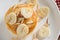Pancakes with banana and almond slice on white dish. Top view.