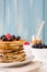 Pancakes with blueberries, raspberry and honey on blue wood