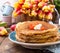 Pancakes with caviar and butter, a bouquet of fresh tulips and a wooden background. Traditional Russian food for carnival. Top