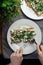 Pancakes with cheese on a plate in a restaurant. Breakfast at the cafe. A woman eats pancakes for breakfast from disposable dishes