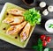 Pancakes with chopped ham and cheese, decorated with lettuce on dark wooden background close up.