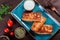 Pancakes with chopped meat and sour cream on dark wooden background close up.