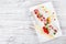 Pancakes with cream cheese, cherries decorated by berries and physalis on light wooden background