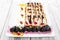 Pancakes with cream cheese, prunes, cherries decorated with chocolate and gold on plate on light wooden bacground