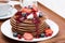 Pancakes with cream, fruit sauce and berries on wooden tray